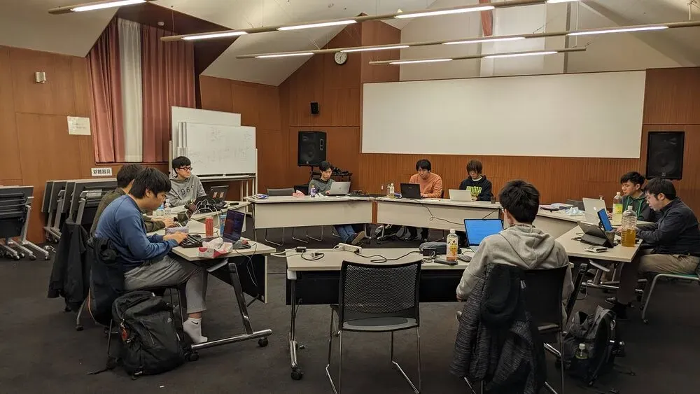 机を輪の形に繋げて作業する様子